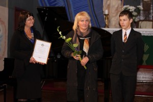 „Inner Whell“ prezidentė Aurelija Mikalauskienė stipendijos sertifikatą įteikia kintiškiui J.Vitkauskui. Šalia jo mokytoja A.Rupšauskienė.